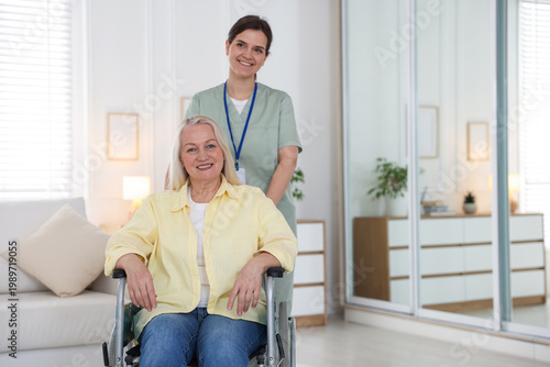 Konstfotografi Portrait of smiling care worker with senior woman in wheelchair at nursing home