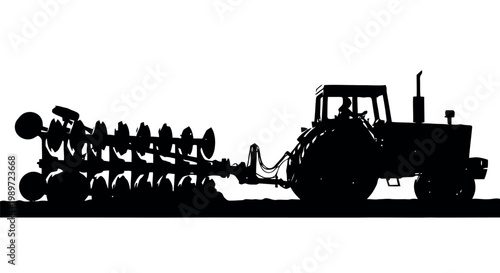 Silhouette of a tractor with a plow on a in a field