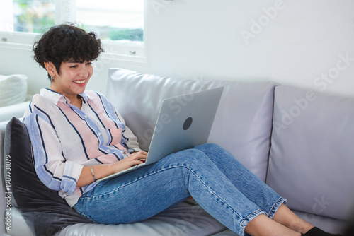 Young woman laptop sofa hom...