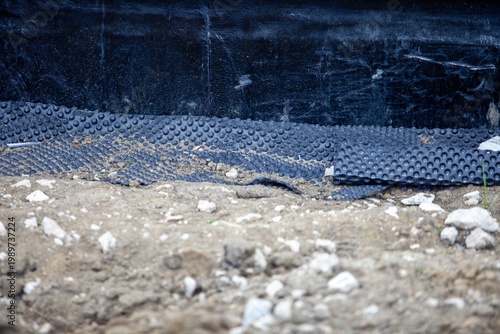 Foto Close-up of black dimpled drainage membrane installed on a concrete foundation w