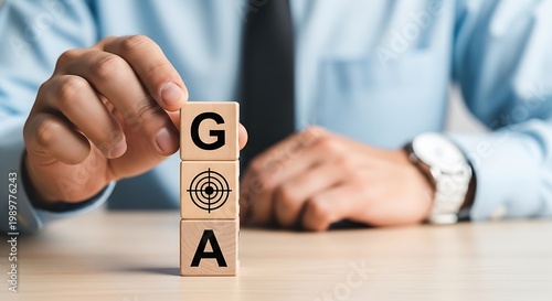 Businessman building goal concept with wooden blocks on a desk