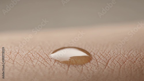 Closeup of a dropper dropping liquid onto human skin