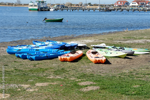 Germany, Mecklenburg Vorpommern, Rerik, April 8, 2026: Many kayaks resting on grass by Rerik saltwater lagoon