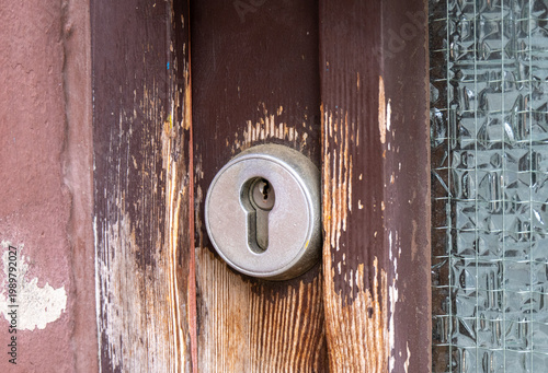 Nahaufnahme eines Türschlosses an einer abgenutzten Tür aus Holz