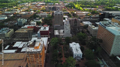 Mix of historic architecture and modern office towers in downtown with tree lined streets in warm evening light Jackson Mississippi USA 
