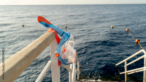 Bild auf Leinwand Ocean breeze rustles plastic snorkel near railing