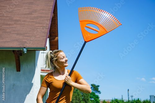 Woman with rake in garden at home