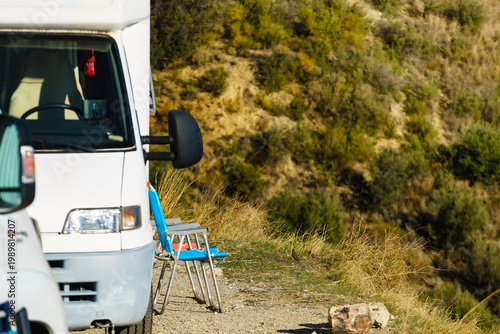 Rv motorhome with two chairs ready for outdoor living. Camping on nature