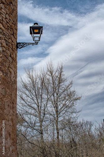 Exterior of city walls with a lamppost and trees in winter