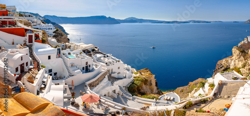Oia town on Santorini island, Greece. Traditional and famous houses and churches with blue domes over the Caldera, Aegean sea