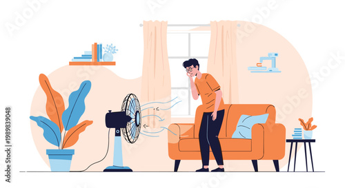 Young man standing in a living room cooling himself down with an electric fan during a hot summer day at home.