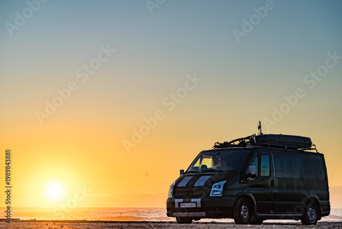 Camper van on beach at sunrise