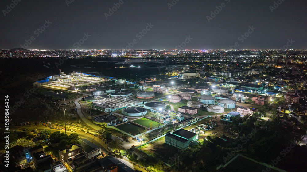 Fototapeta premium Sewage treatment plant illuminated at night with industrial infrastructure