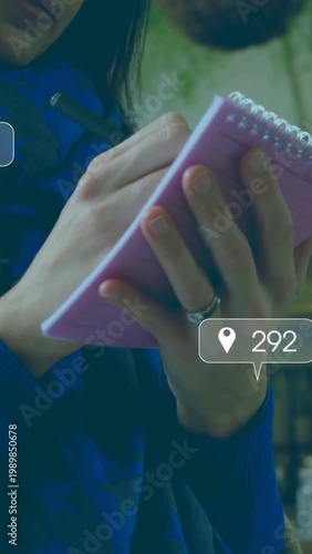 Man holding pink notepad and tapping pen, tracking social media metrics animating around pad