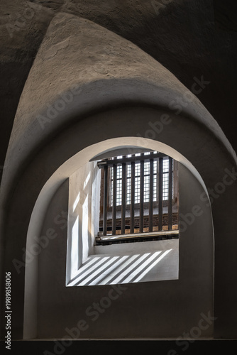 Window with bars and light shafts in an old building