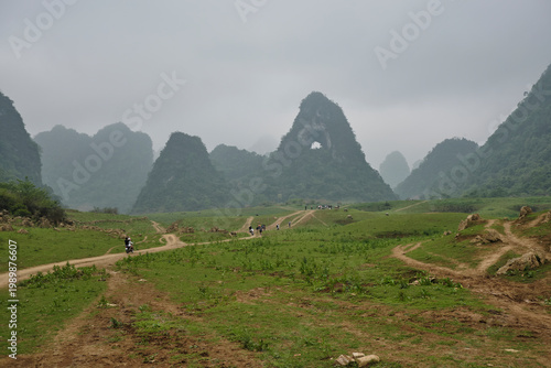 Mui Pia mountain with natural rock arch in Cao Bang Vietnam, landscape with karst peaks, moody atmosphere, rural travel adventure