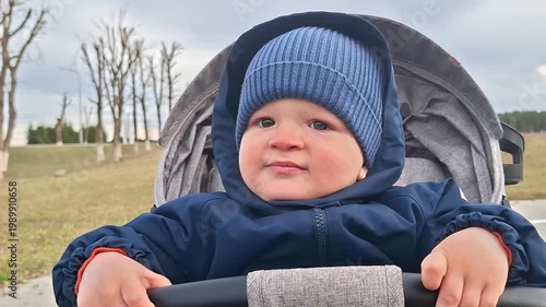 Adorable toddler boy in stroller enjoying fresh air outdoors