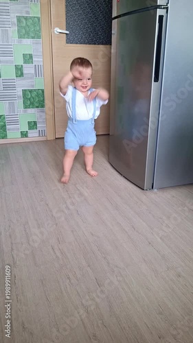 Adorable toddler boy taking first steps at home