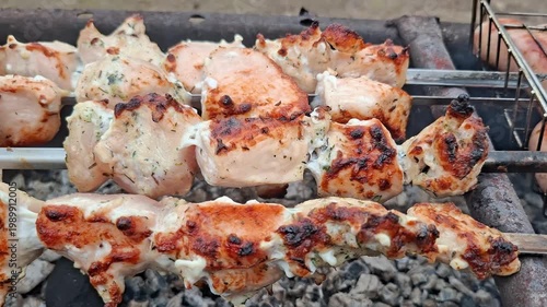 Juicy chicken shashlik and sausages cooking on barbecue grill