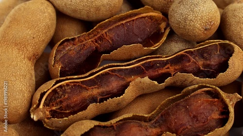 Brown tamarind fruit pods circle rotation close up