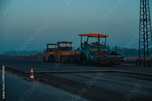 Road construction machinery working at dusk