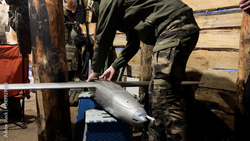 Foto Serviceman in a dugout preparing an aircraft-type attack drone before launch
