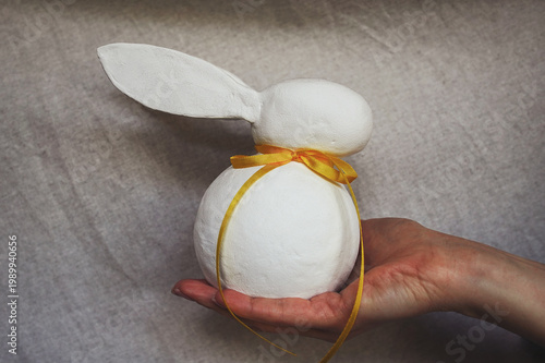 Easter bunny with yellow ribbon in the hand