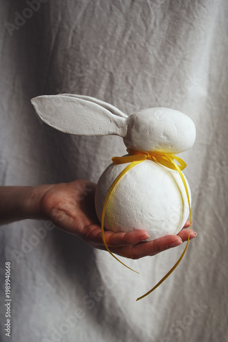 Easter bunny with yellow ribbon in the hand
