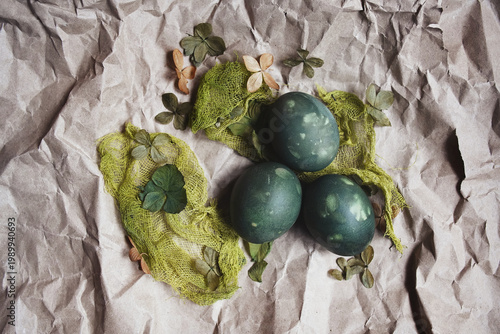 Natural Easter decoration with dried petals, colored egg, and craft paper