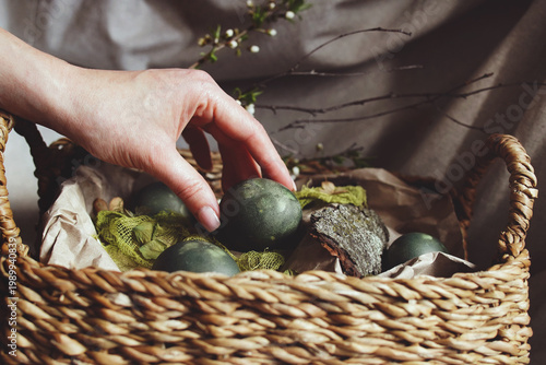 Natural Easter decorations, gently placing colored green easter egg for a natural Easter display