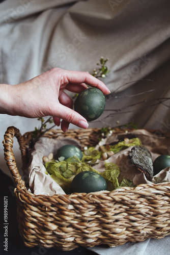 Natural Easter decorations, gently placing colored green easter egg for a natural Easter display