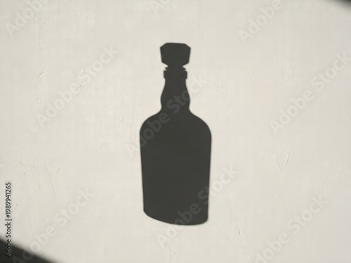 Dark silhouette of a liquor bottle on a neutral beige background with dramatic lighting