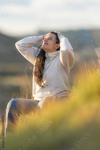 Young woman enjoying nature raising hands head
