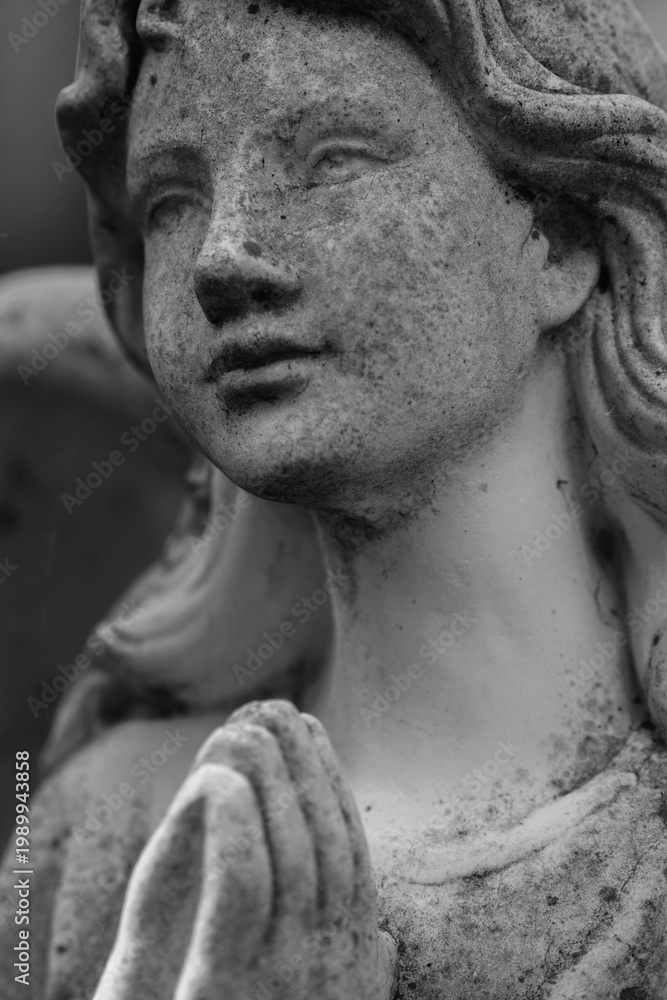 Fototapeta premium Black and white image of angel sculpture in prayer, concept of belief, devotion and inner calm