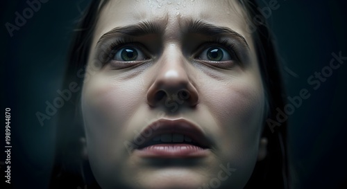 Close-up of Young Woman's Face with Wide Eyes and Sweat, Expressing Intense Fear and Anxiety