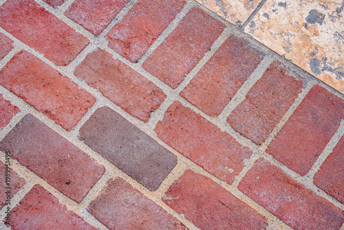 Foto Close-up view of a red brick pathway laid in a herringbone pattern with stone ac
