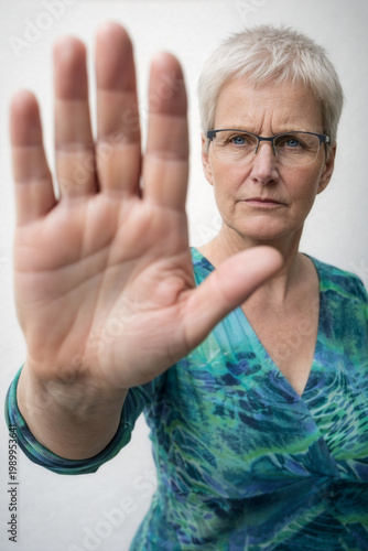 Seniorin signalisiert Halt: Nein zu Gewalt und Diskriminierung