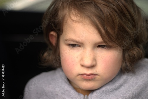 Serious young boy with thoughtful expression, close-up portrait