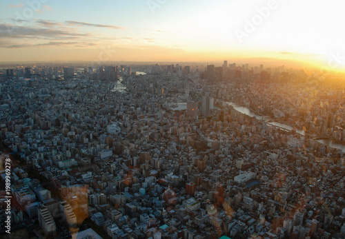 Aerial view of Tokyo at sunset from Tokyo Skytree, featuring dense urban skyline and rivers reflecting warm evening light