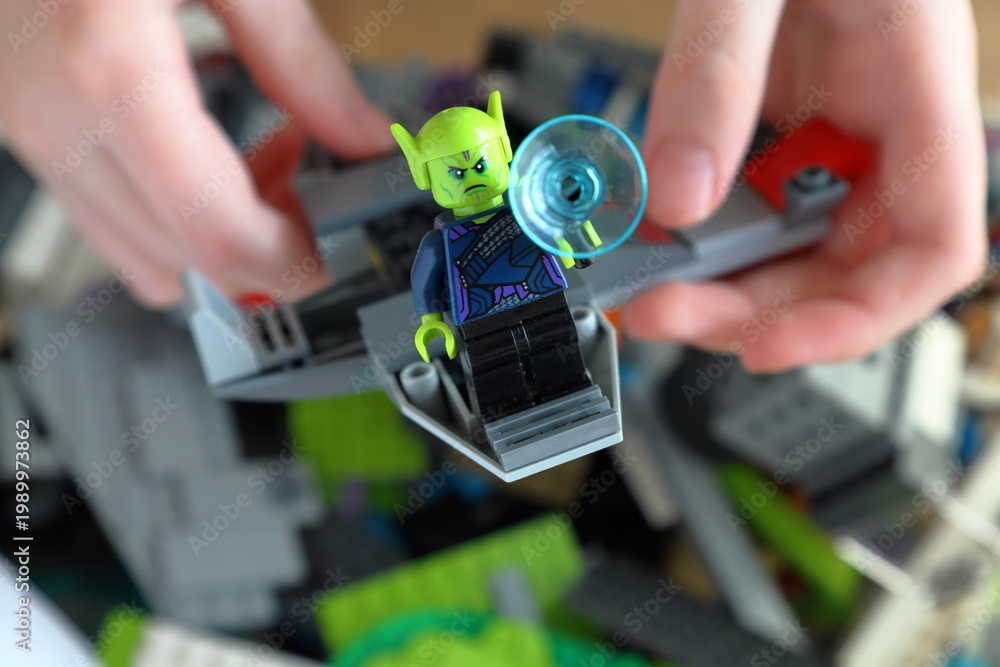 Fototapeta premium Kid playing with Lego. Assembly bricks or blocks in plastic. Hand visible.