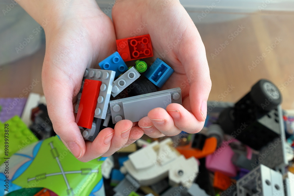 Obraz premium Kid playing with Lego. Assembly bricks or blocks in plastic. Hand visible.