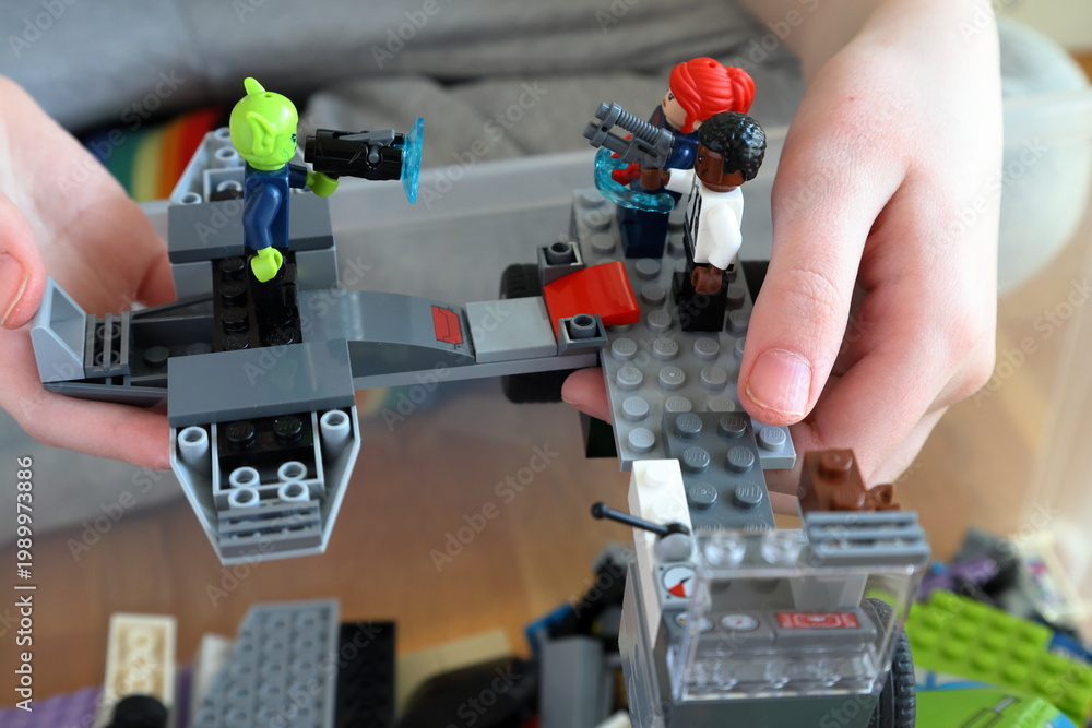 Obraz premium Kid playing with Lego. Assembly bricks or blocks in plastic. Hand visible.