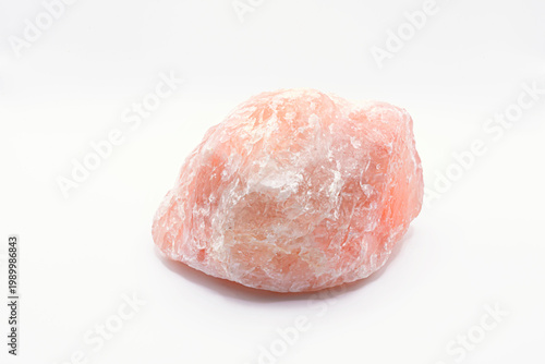 A close up image of an unpolished rose quartz crystal isolated on a white background. The unpolished crystal showed the rough texture of the rose quartz crystal. 