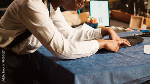 Fotografija Seamstress preparing fabric on table, measuring material for right fit, custom made clothes