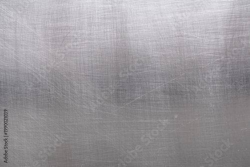 Close-up of brushed aluminum texture background with light reflection, industrial metallic surface.