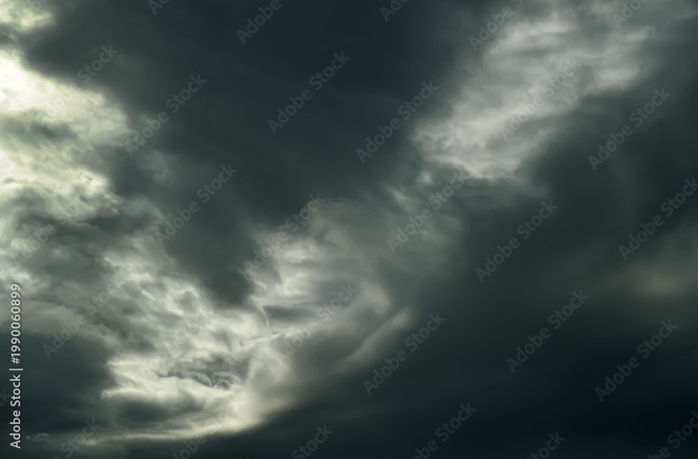Obraz premium Dark dramatic storm clouds with light breaking through, moody sky background