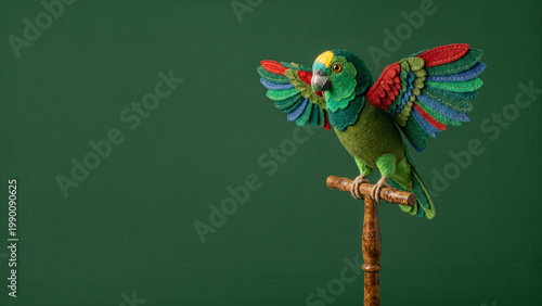 Needle-felted Amazon parrot with colorful stitched wings perched on a wooden stand against a minimalist dark green background with copy space.