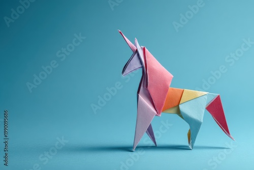 Multicolored paper unicorn origami figure against a blue background.
