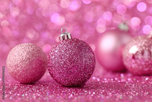 Pink glittery christmas ornaments on sparkling surface background