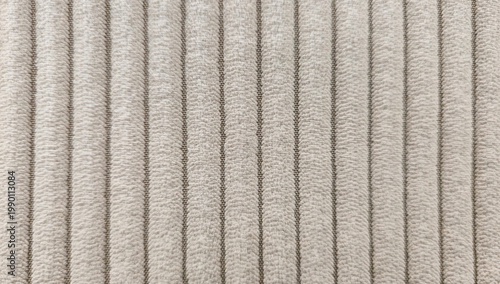 Textured fabric surface with vertical ribbed pattern, neutral tone textile.